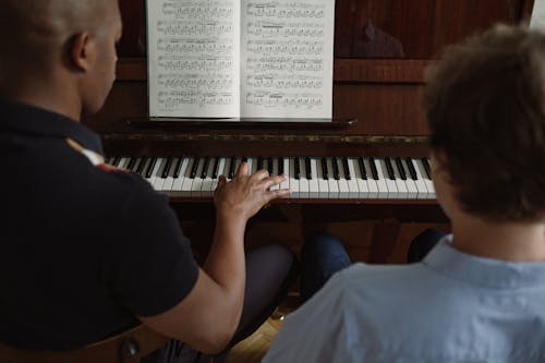 Man and Boy Playing Piano Together