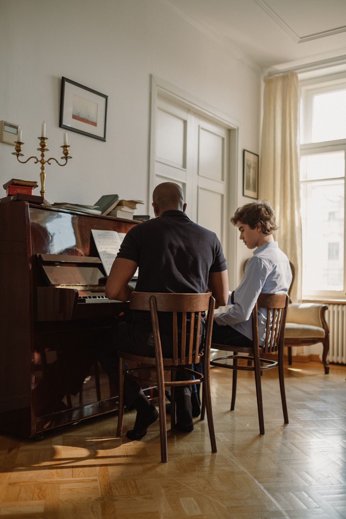 Teacher guiding a student through a piano lesson