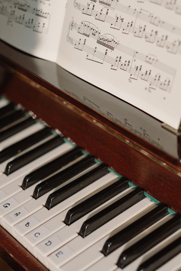 Close-up Photo Of A Piano Keys And Sheet Music