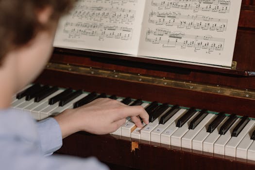 A person playing a piano with a focus on hands and sheet music, highlighting musical practice.