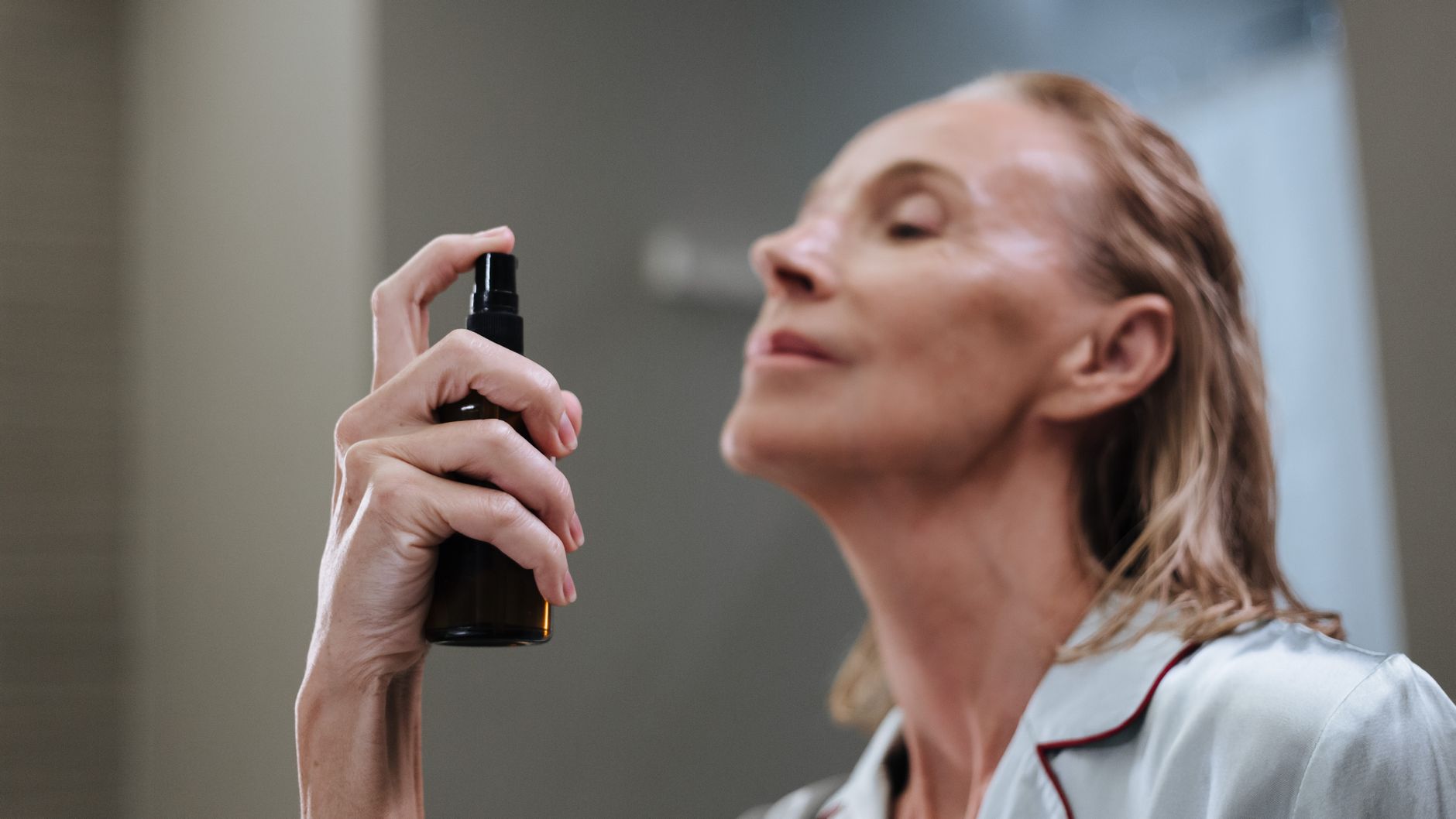 Woman applying hypochlorous acid face mist — HOCl spray used for daily skin care
