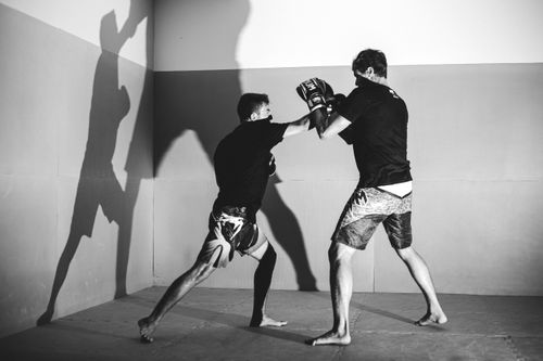 Free Two men engage in intense boxing training, captured in black and white. Stock Photo
