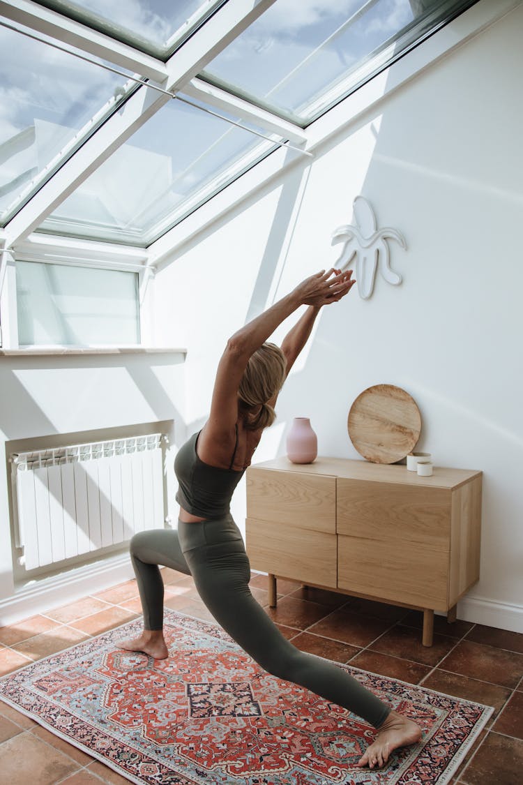 Woman Doing Fitness On Carpet In Attic Room