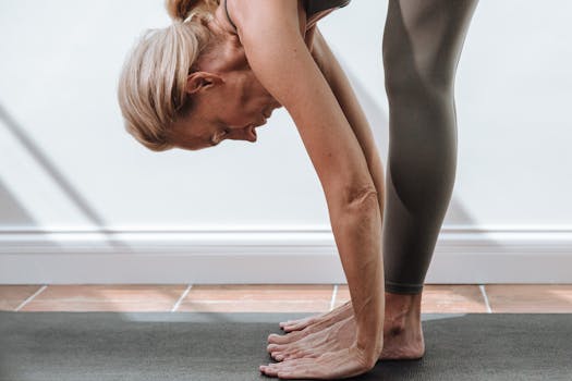 A senior woman performing a yoga pose indoors, embodying health and mindfulness.