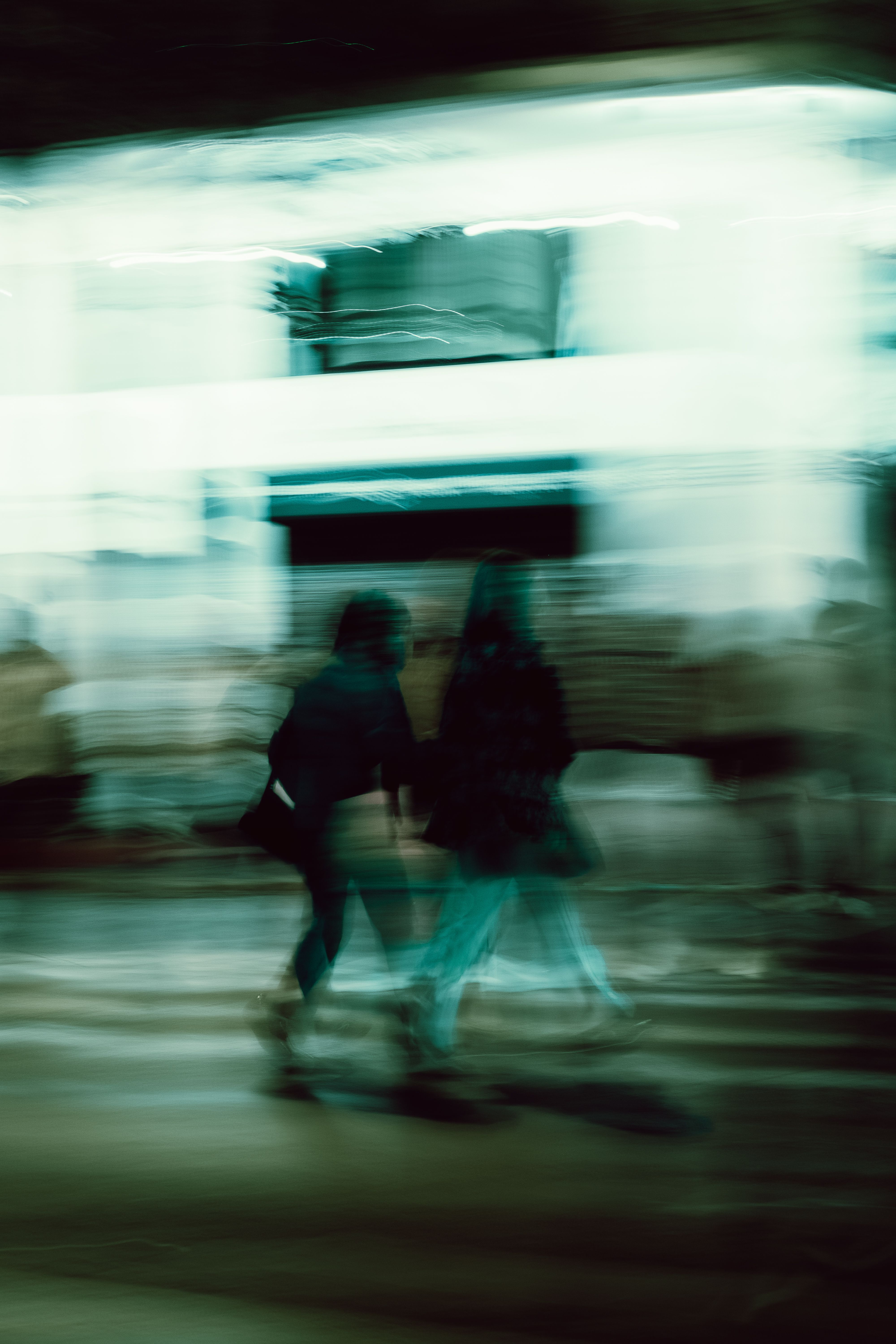 Abstract motion blur of pedestrians walking at night in Athens, Greece.