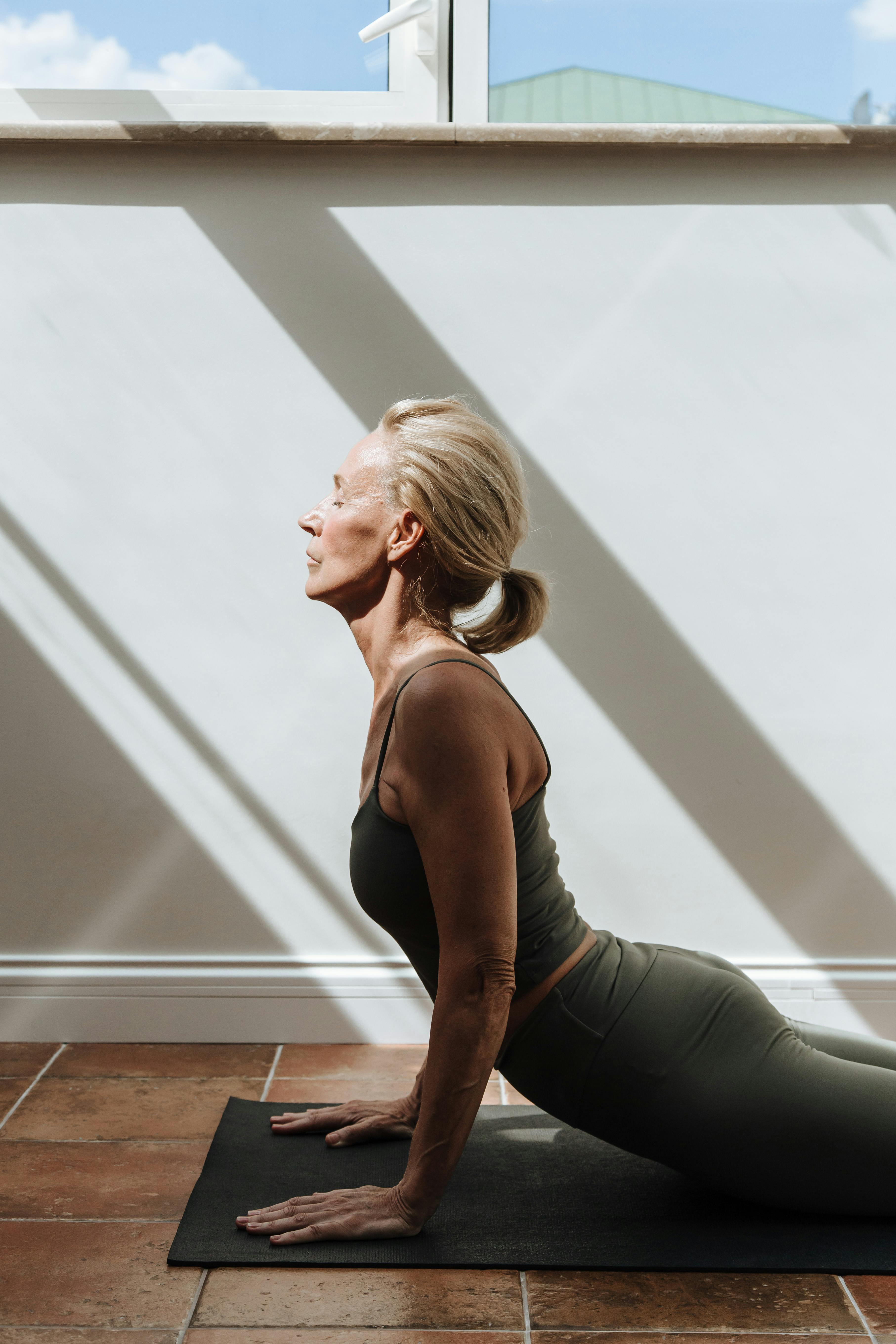 woman practicing sport on mat in room