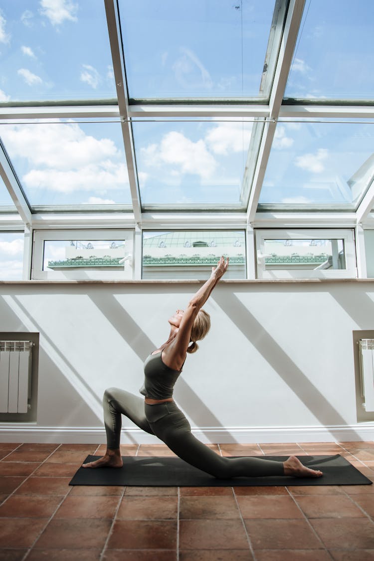 Woman Doing Stretching In Room With Glass Ceiling