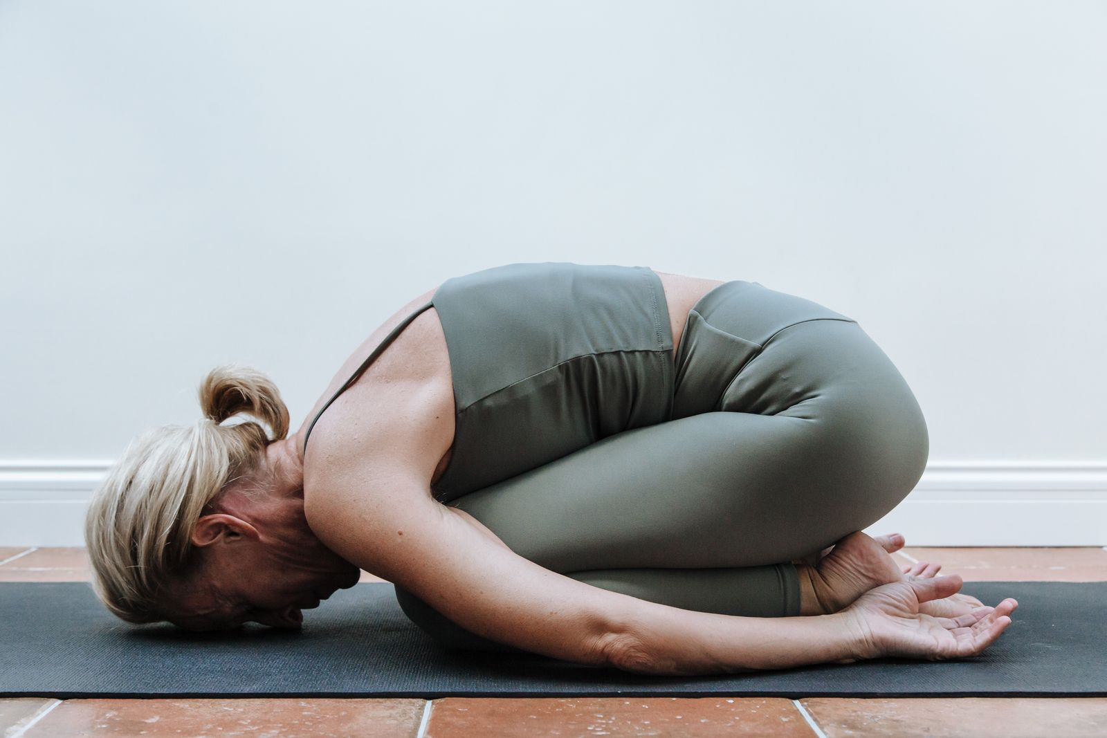 Practitioner resting in a long-held child's pose stretch typical of a yin yoga class