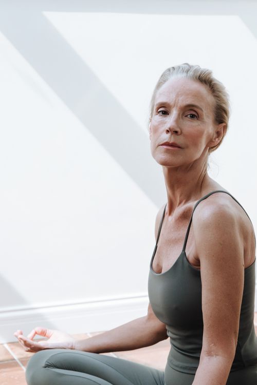 Free Serene senior woman practicing yoga indoors with natural light. Stock Photo