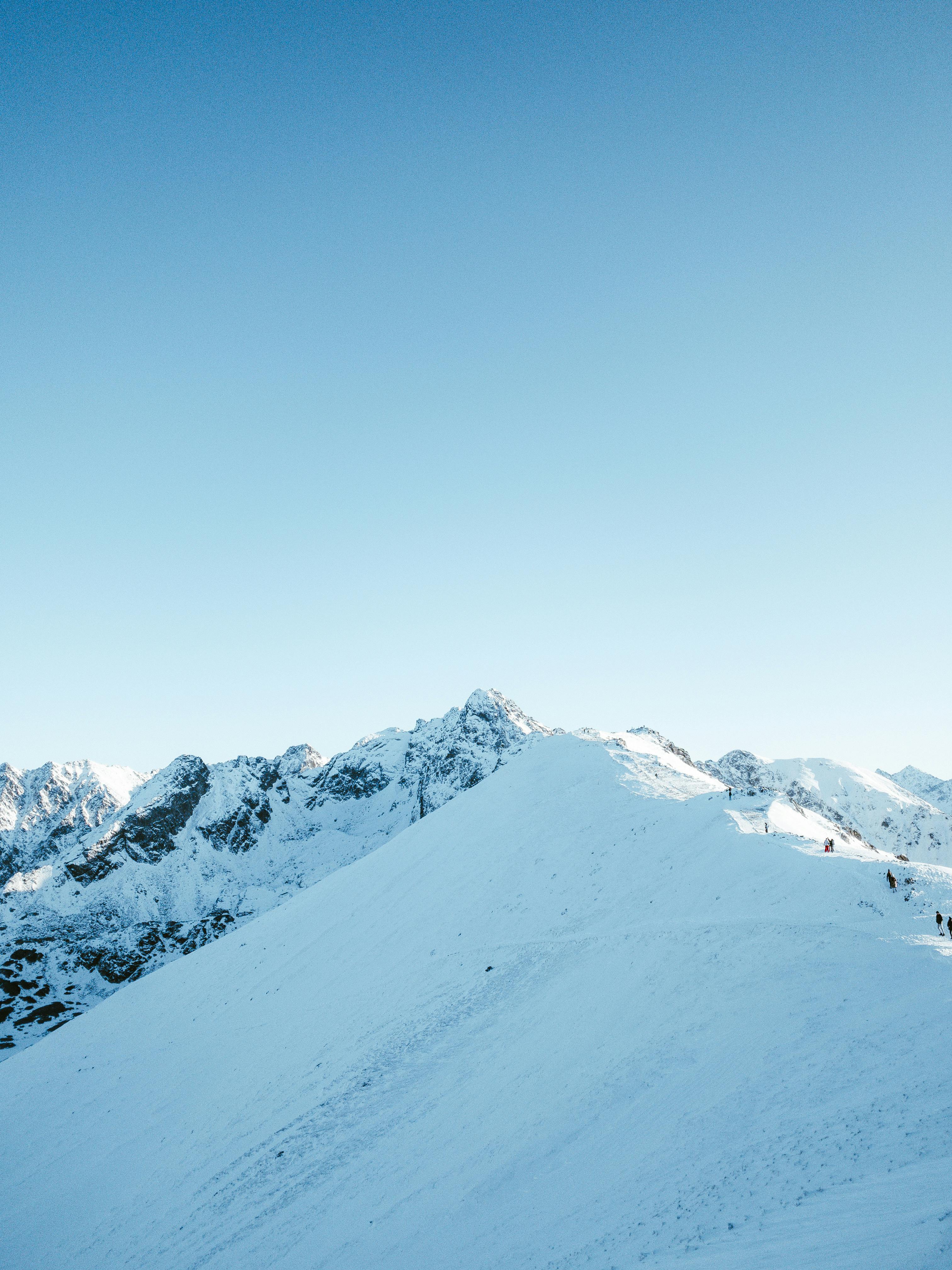 Majestic snow-covered mountains under a clear blue sky in Zakopane, Poland.