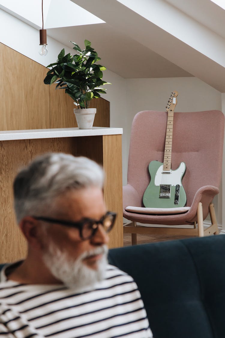 Electric Guitar On Chair Behind Man