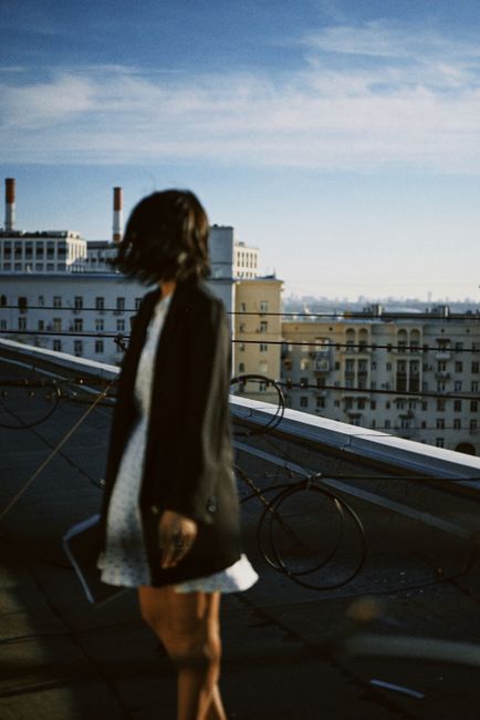 Blurred woman on rooftop with cityscape background, urban exploration idea.
