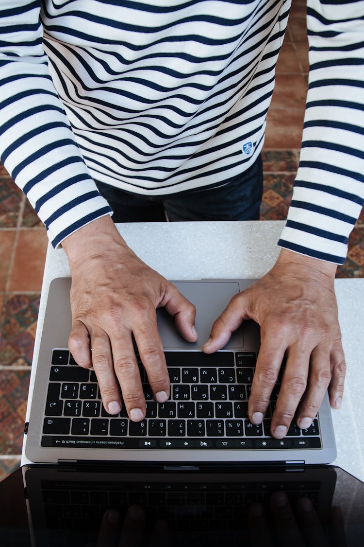 A Directly Above Shot Of Senior Adult Male Hands Typing On Laptop 