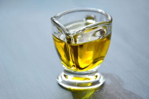 A close-up photo of a small glass jug containing yellow liquid against a white background.