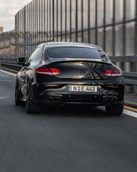 Sleek black Mercedes Benz in motion on a highway in Nürnberg. Urban setting, capturing speed and elegance.