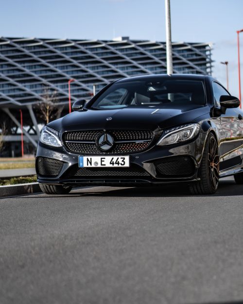 Free A sleek black Mercedes Benz coupe parked in Nürnberg, featuring modern architecture in the background. Stock Photo
