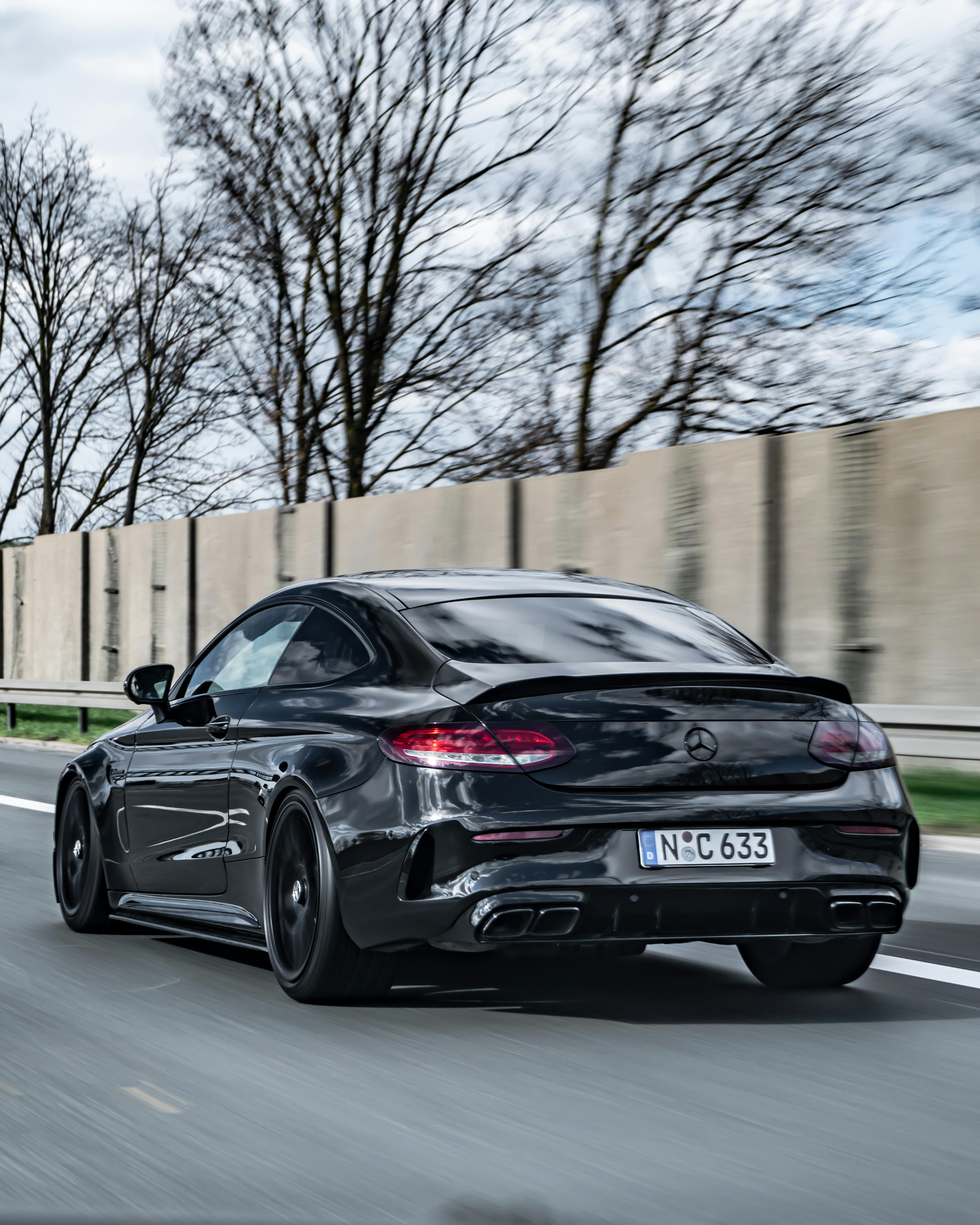 back view of a black mercedes benz on a road