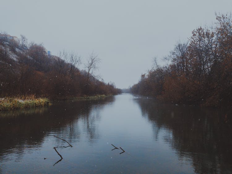 Snowfall Over Calm River