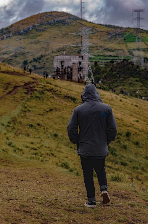 A Person wearing Hoodie Walking on Grass 