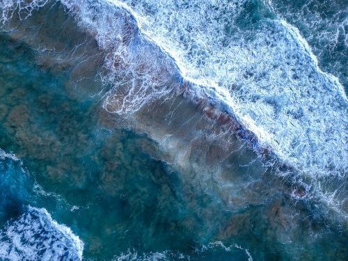 Free Stunning aerial capture of ocean waves crashing in Amanzimtoti, KZN, South Africa. Stock Photo