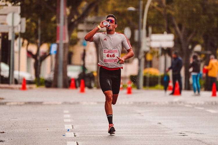 A Man Drinking Water While Running