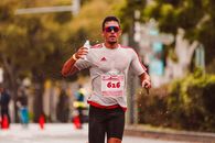 Man in White and Red Nike Soccer Jersey Running on Road