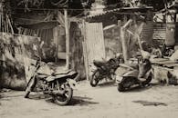 在乡村和城市环境中，以单色拍摄了三辆摩托车和滑板车