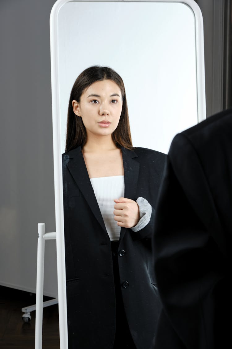 A Woman In A Blazer Looking At The Mirror 