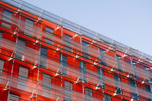 Free Striking red glass facade showcasing modern urban architecture under clear skies. Stock Photo