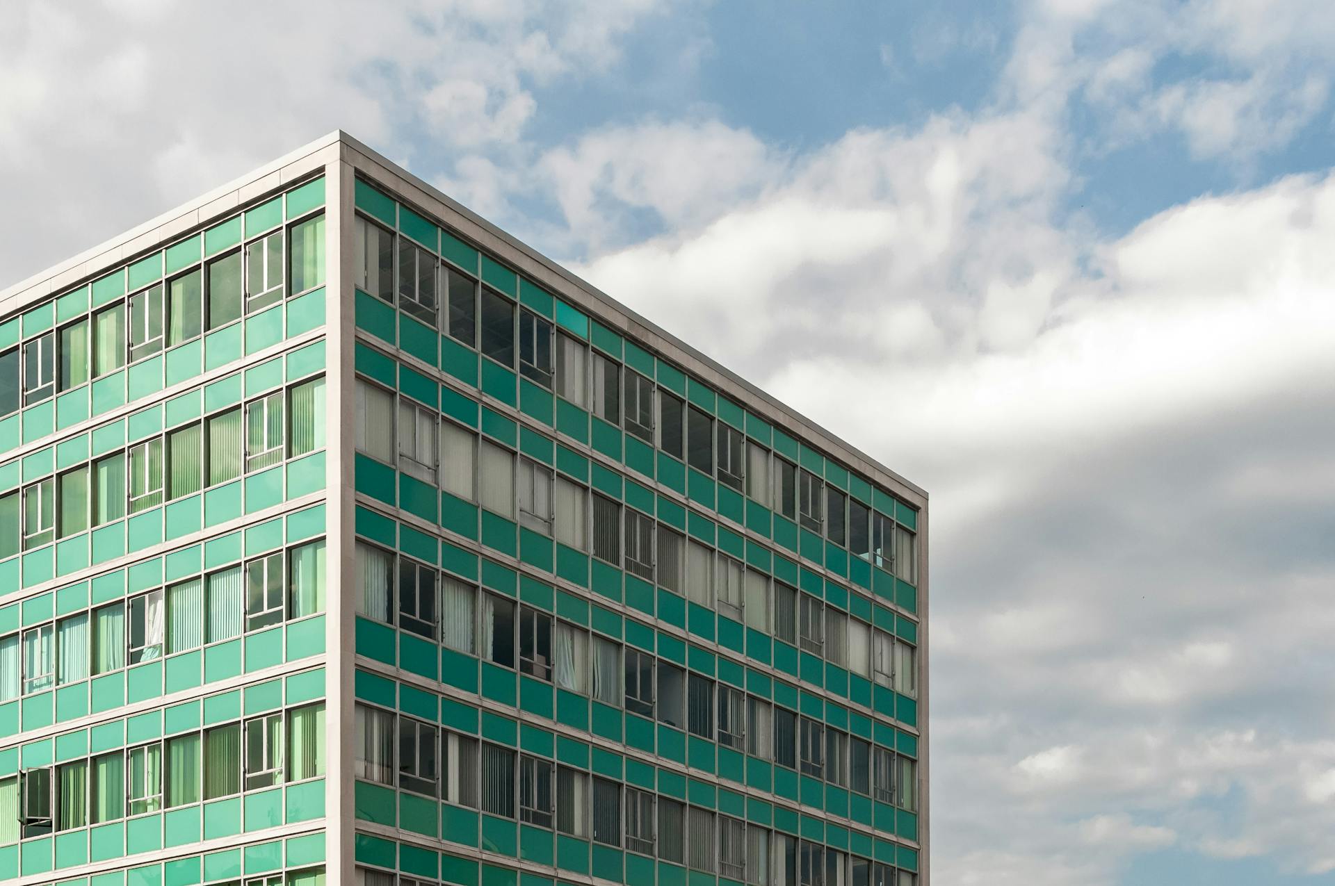 A modern office building in London, Ontario, showcasing a geometric design against a cloudy sky.