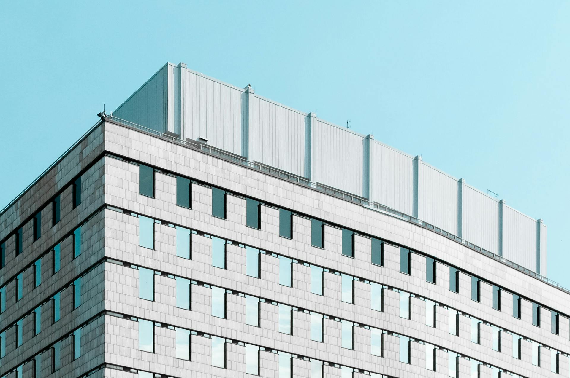 Contemporary office building facade in London, ON, Canada with clear blue sky.