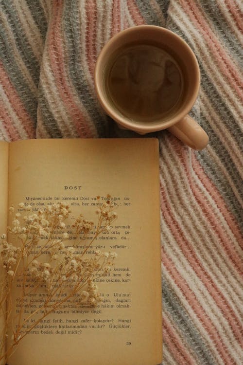 A Cup of Coffee and a Book on a Surface