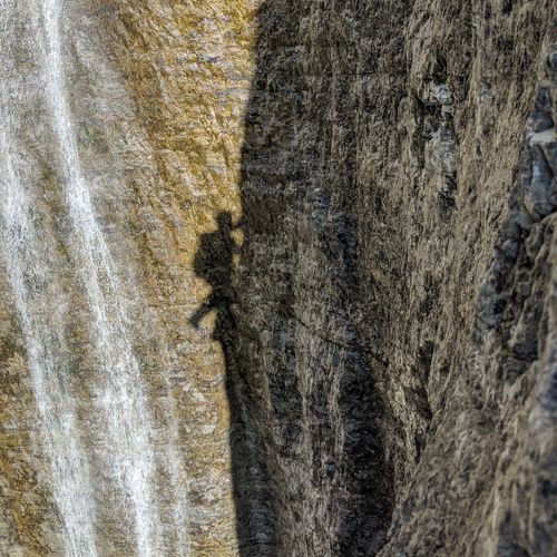 Free Impressive shadow of a rock climber on a steep cliff in Trentino-Alto Adige, Italy, showcasing outdoor adventure. Stock Photo