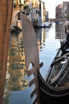 标志性的贡多拉航行在风景优美的威尼斯运河上，倒映着历史建筑