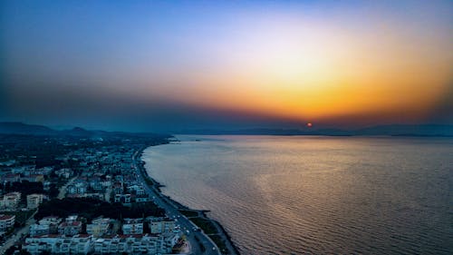 Free Bird's Eye View of City Near Ocean During Dawn Stock Photo