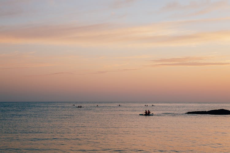 People On Kayaks In The Sea At Sunset 