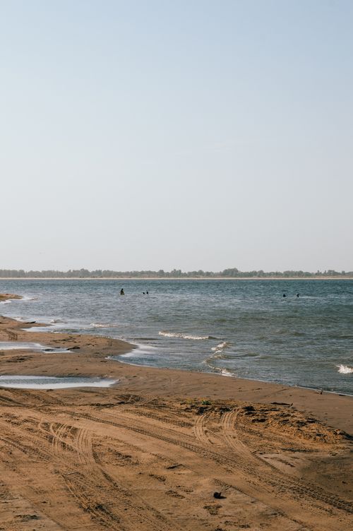 Free Serene view of a sandy beach with gentle waves in Astrakhan, Russia. Stock Photo