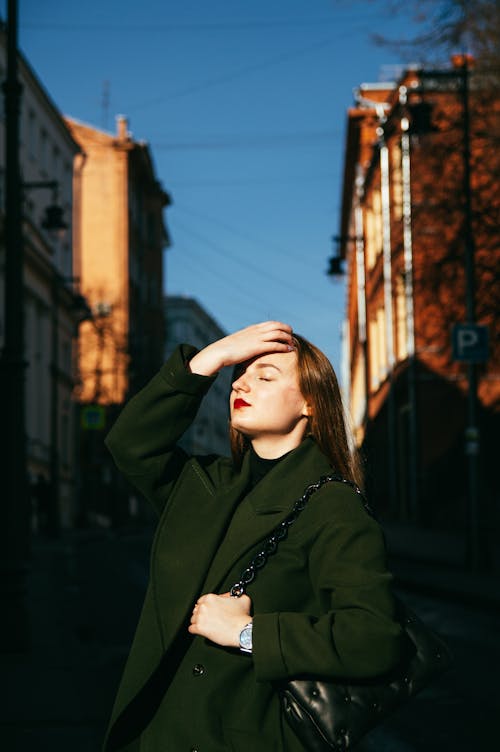 Free Girl in a City Exposing Her Face to the Sun  Stock Photo