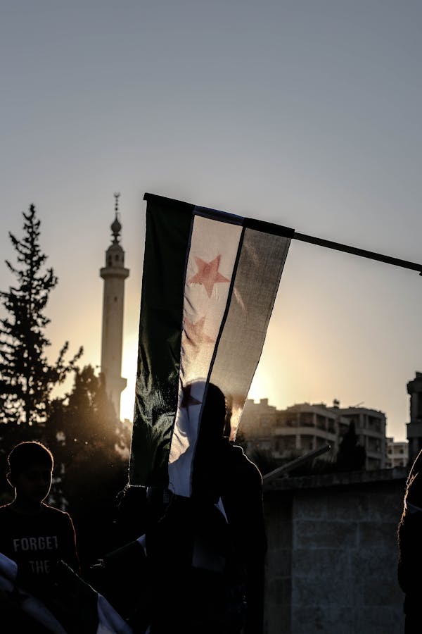 Men in a City and Syrian Flag