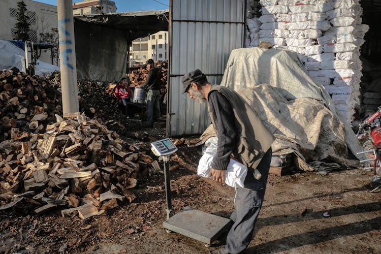 Man Weighing Chopped Wood 