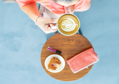 Top View Photography of a Woman Holding Coffee Cup