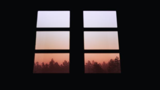 Gorgeous sunrise through a window, overlooking a misty forest in Norway.