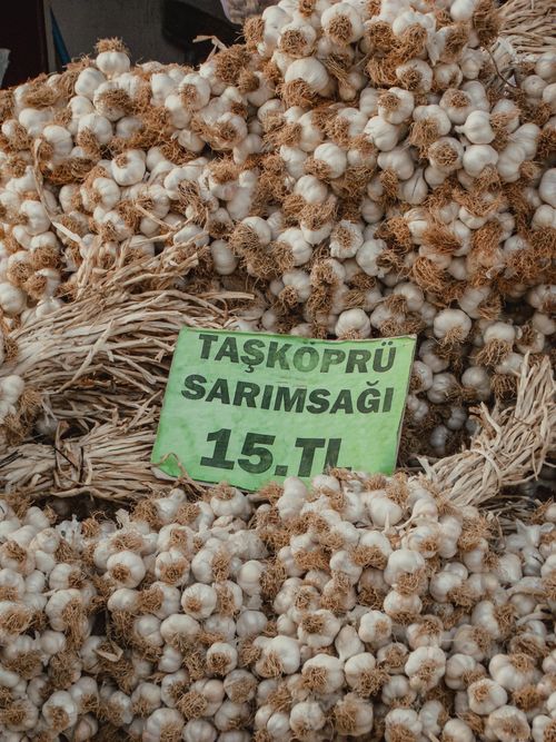 Free A stack of fresh Taşköprü garlic with a price sign at a market in Turkey. Stock Photo