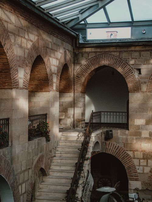 Free Elegant courtyard with arches, stone staircase, and skylight, capturing historical architecture. Stock Photo