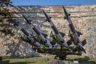 Missiles on Display Near a Stone Wall