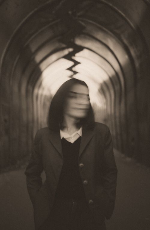 Free Artistic photo of a woman with blurred face in a grunge tunnel, conveying mystery. Stock Photo