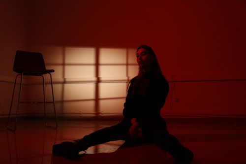 Free Dramatic portrait of a woman under red lighting, with shadows creating a mysterious atmosphere. Stock Photo