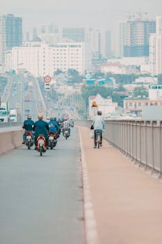 Motorcycles and bicycles sharing a city highway at daytime, showcasing urban transportation dynamics.