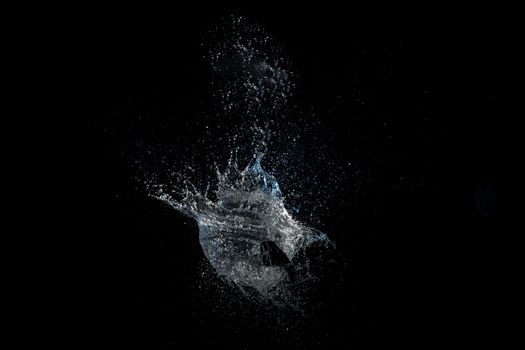 Dynamic capture of a water splash with droplets on a black background.