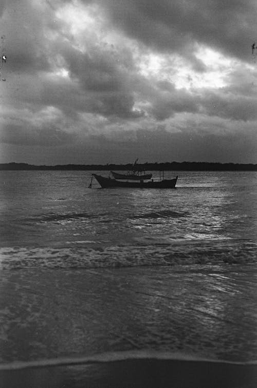 Grayscale Photo of Boat on Sea